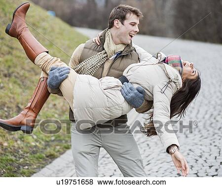 Happy man carrying woman in park View Large Photo Image Stock Photo - Happy man carrying woman in park. Fotosearch