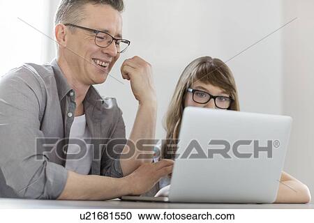 Happy man using laptop with daughter at home View Large Photo Image Stock Image - Happy man using laptop with daughter at home. Fotosearch