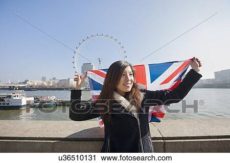 Happy woman with British flag against London Eye at London, England, UK View Large Photo Image Stock Image - Happy woman with British flag against London Eye at London, England, UK. Fotosearch