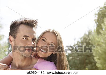 Happy young couple enjoying quality time in park View Large Photo Image Stock Image - Happy young couple enjoying quality time in park. Fotosearch