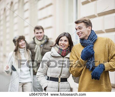 Picture - Happy young couples in warm clothing enjoying vacation. Fotosearch
