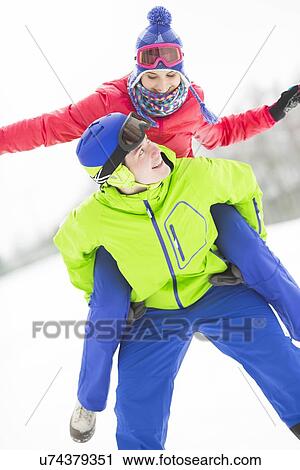 Happy young man giving piggyback ride to woman in snow View Large Photo Image Stock Image - Happy young man giving piggyback ride to woman in snow. Fotosearch