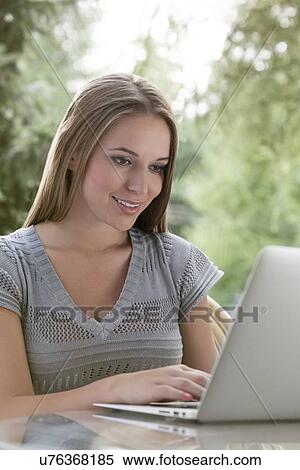 Happy young woman using laptop outdoors View Large Photo Image Stock Photography - Happy young woman using laptop outdoors. Fotosearch