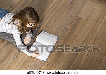 High angle view of teenage girl reading book on floor at home View Large Photo Image Stock Image - High angle view of teenage girl reading book on floor at home. Fotosearch