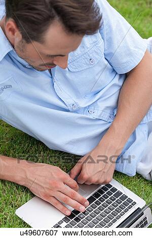 High angle view of young man using laptop in park View Large Photo Image Stock Photo - High angle view of young man using laptop in park. Fotosearch