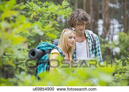 Hiking couple reading map together in forest View Large Photo Image Stock Image - Hiking couple reading map together in forest. Fotosearch