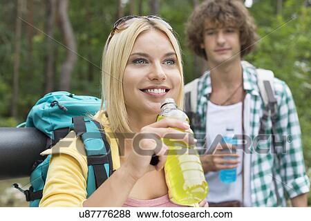 Hiking couple with energy drinks in forest View Large Photo Image Stock Photo - Hiking couple with energy drinks in forest. Fotosearch