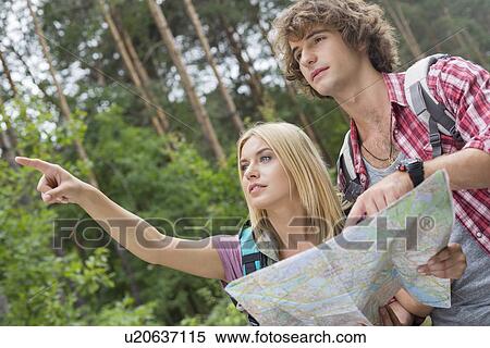Hiking couple with map discussing over direction in forest View Large Photo Image Stock Photography - Hiking couple with map discussing over direction in forest. Fotosearch