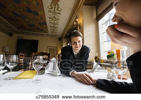 Loving business couple holding hands at restaurant table View Large Photo Image Stock Photo - Loving business couple holding hands at restaurant table. Fotosearch