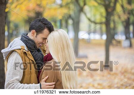 Loving couple hugging in park View Large Photo Image Stock Image - Loving couple hugging in park. Fotosearch