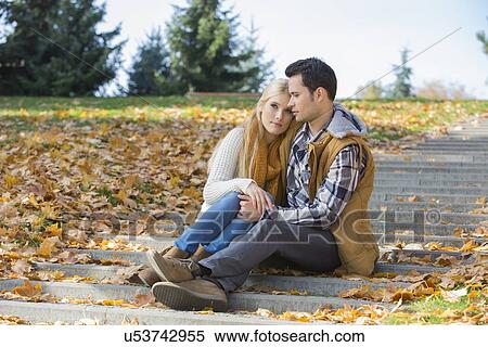 Loving couple sitting together on steps in park during autumn View Large Photo Image Stock Photography - Loving couple sitting together on steps in park during autumn. Fotosearch