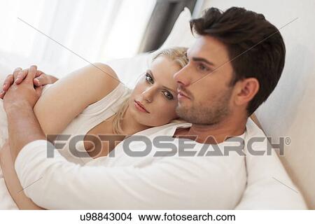 Loving young couple embracing in bed View Large Photo Image Picture - Loving young couple embracing in bed. Fotosearch