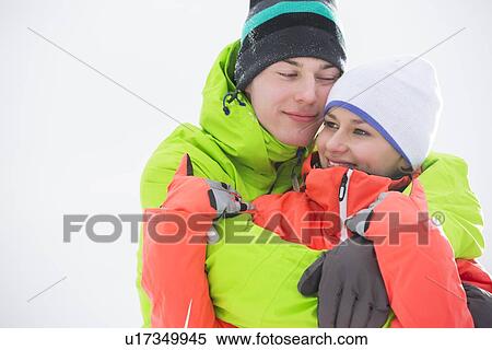 Loving young couple in warm clothing embracing outdoors View Large Photo Image Stock Photography - Loving young couple in warm clothing embracing outdoors. Fotosearch