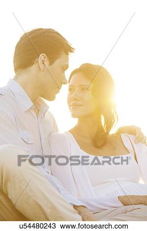Loving young couple looking at each other against clear sky View Large Photo Image Stock Image - Loving young couple looking at each other against clear sky. Fotosearch