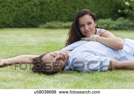 Stock Photo - Loving young couple relaxing in park. Fotosearch