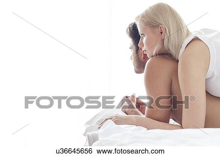 Stock Photograph - Loving young woman on man in hotel room. Fotosearch