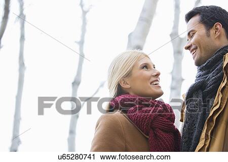 Low angle view of couple looking at each other in park during autumn View Large Photo Image Stock Image - Low angle view of couple looking at each other in park during autumn. Fotosearch