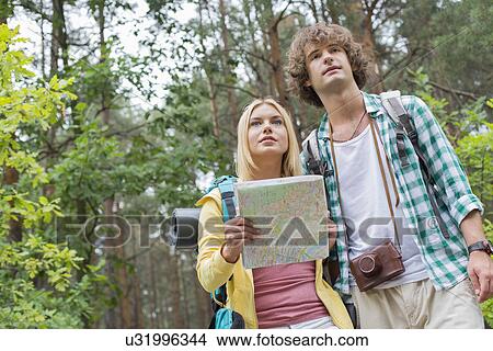 Low angle view of hiking couple with map in forest View Large Photo Image Picture - Low angle view of hiking couple with map in forest. Fotosearch