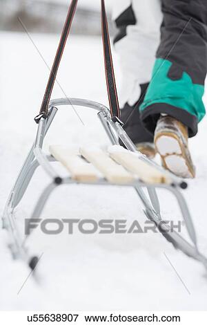Low section of man with sled walking in snow View Large Photo Image Stock Photo - Low section of man with sled walking in snow. Fotosearch