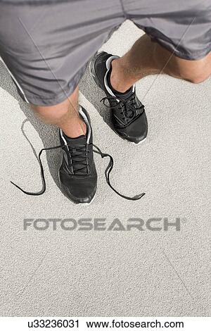 Low section of sporty man with untied shoelace standing on street View Large Photo Image Stock Image - Low section of sporty man with untied shoelace standing on street. Fotosearch