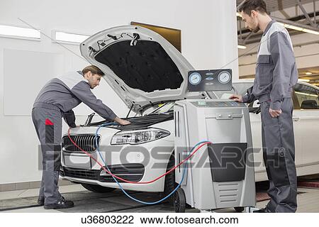 Male automobile mechanics examining car in repair shop View Large Photo Image Stock Image - Male automobile mechanics examining car in repair shop. Fotosearch