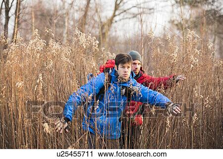 Stock Image - Male backpackers in field. Fotosearch