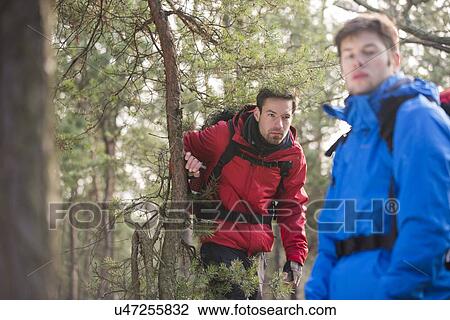 Stock Image - Male backpackers in forest. Fotosearch
