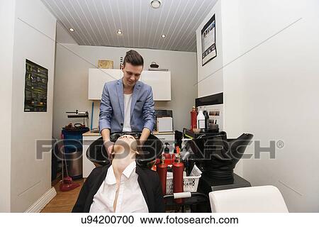 Male hairstylist washing female customer's hair in beauty salon View Large Photo Image Stock Image - Male hairstylist washing female customer's hair in beauty salon. Fotosearch