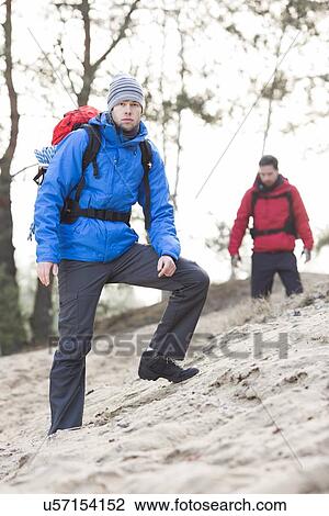 Male hiker at forest with friend in background View Large Photo Image Stock Image - Male hiker at forest with friend in background. Fotosearch