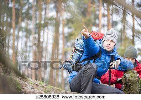 Stock Photo - Male hiker pointing in forest. Fotosearch