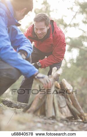 Male hikers lighting bonfire in forest View Large Photo Image Stock Photo - Male hikers lighting bonfire in forest. Fotosearch