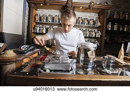 Male owner measuring ingredient on weight scale in tea store View Large Photo Image Stock Image - Male owner measuring ingredient on weight scale in tea store. Fotosearch