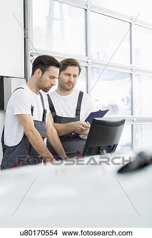 Male repair workers working in automobile repair shop View Large Photo Image Picture - Male repair workers working in automobile repair shop. Fotosearch