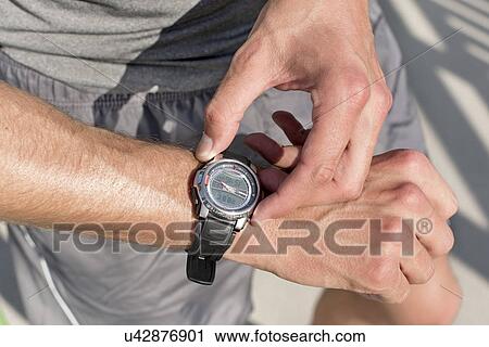 Midsection of fit man checking time on path in park View Large Photo Image Stock Image - Midsection of fit man checking time on path in park. Fotosearch