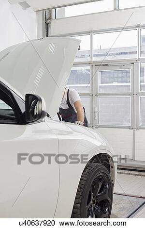 Midsection of male automobile mechanic examining car engine in workshop View Large Photo Image Stock Image - Midsection of male automobile mechanic examining car engine in workshop. Fotosearch