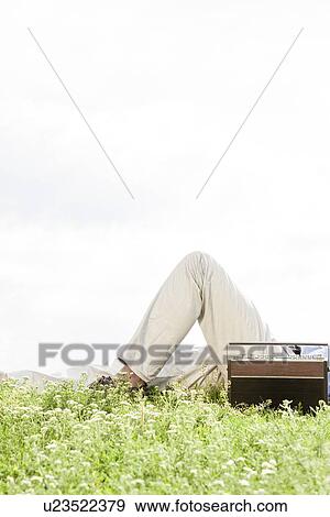 Midsection of man lying by vintage radio on grass against clear sky View Large Photo Image Stock Photo - Midsection of man lying by vintage radio on grass against clear sky. Fotosearch