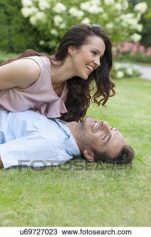 Stock Image - Playful young couple having leisure time in park. Fotosearch
