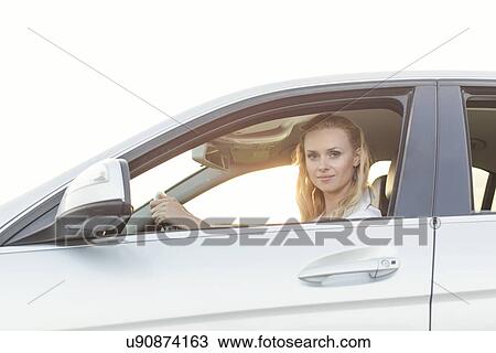 Stock Image - Portrait of beautiful woman driving car. Fotosearch