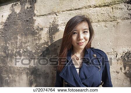 Portrait of beautiful woman smiling while leaning on wall at London, England, UK View Large Photo Image Picture - Portrait of beautiful woman smiling while leaning on wall at London, England, UK. Fotosearch