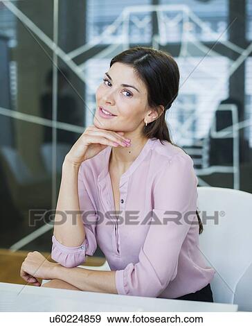 Stock Photo - Portrait of beautiful young businesswoman at conference table. Fotosearch