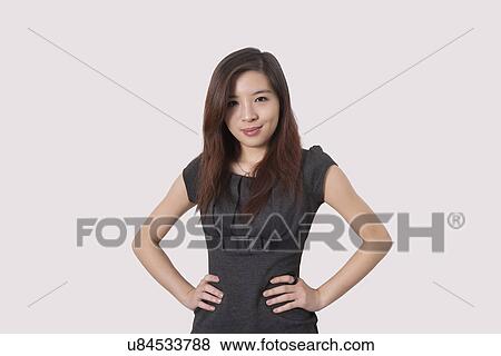 Portrait of beautiful young businesswoman with hands on hips over white background View Large Photo Image Stock Photo - Portrait of beautiful young businesswoman with hands on hips over white background. Fotosearch