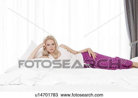 Portrait of beautiful young woman lying in hotel room View Large Photo Image Stock Image - Portrait of beautiful young woman lying in hotel room. Fotosearch