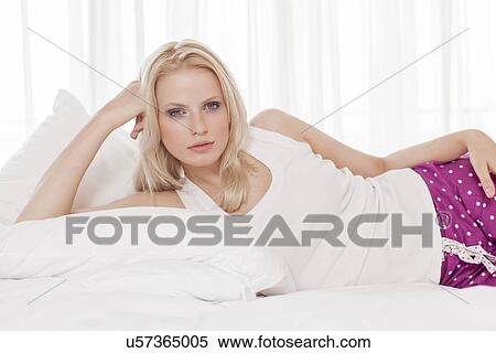 Portrait of beautiful young woman lying in hotel room View Large Photo Image Stock Photography - Portrait of beautiful young woman lying in hotel room. Fotosearch