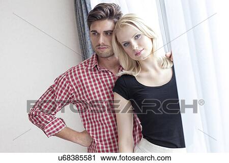 Portrait of beautiful young woman with man at window in hotel room View Large Photo Image Stock Image - Portrait of beautiful young woman with man at window in hotel room. Fotosearch