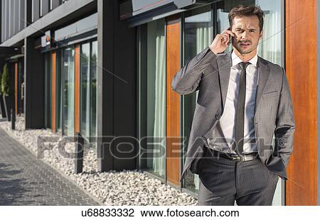Portrait of businessman using cell phone outside office View Large Photo Image Stock Image - Portrait of businessman using cell phone outside office. Fotosearch