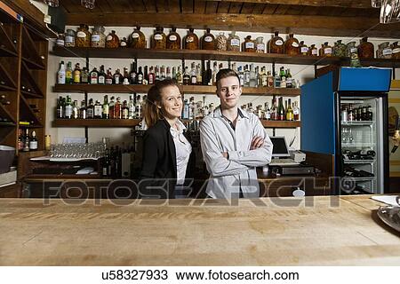 Stock Image - Portrait of confident bartenders at counter in restaurant. Fotosearch