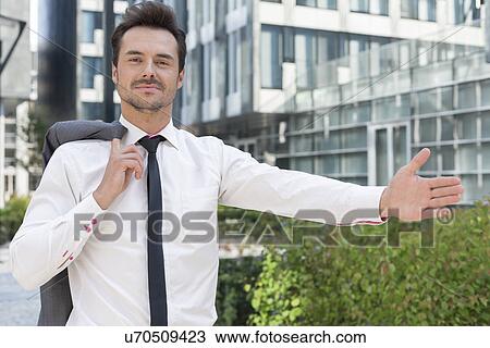 Portrait of confident businessman gesturing while standing outside office building View Large Photo Image Stock Image - Portrait of confident businessman gesturing while standing outside office building. Fotosearch
