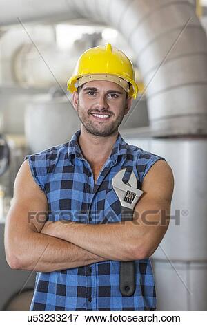 Stock Photo - Portrait of confident industrial worker standing arms crossed. Fotosearch