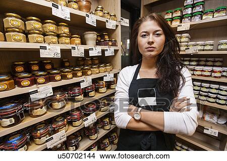 Portrait of confident saleswoman standing arms crossed in grocery store View Large Photo Image Picture - Portrait of confident saleswoman standing arms crossed in grocery store. Fotosearch