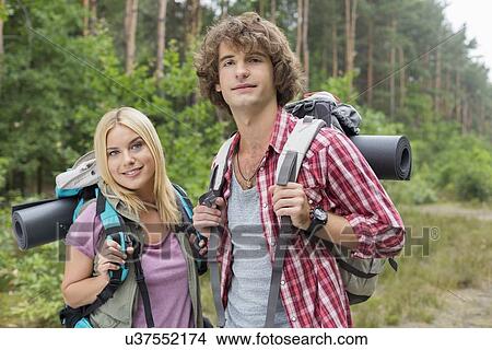 Picture - Portrait of confident young hiking couple in forest. Fotosearch